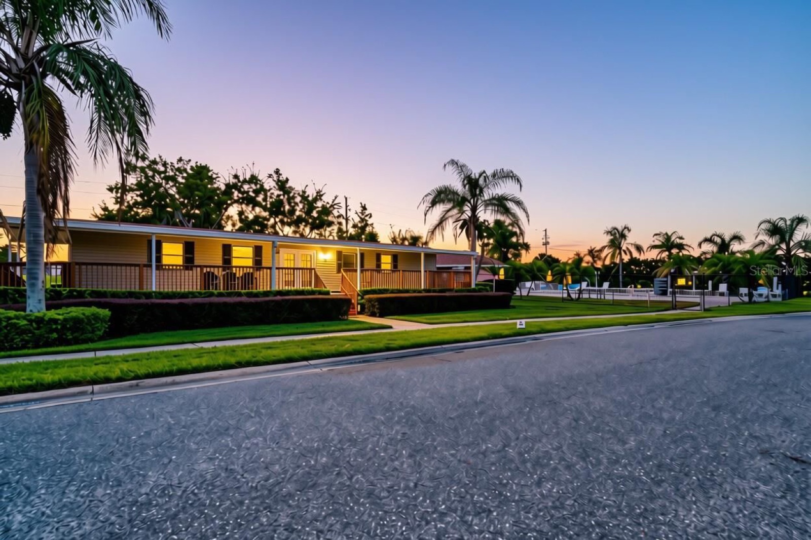 A palm-lined street in the community at dusk